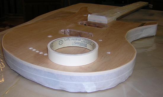 Taping off the front of the guitar prior to applying dye.