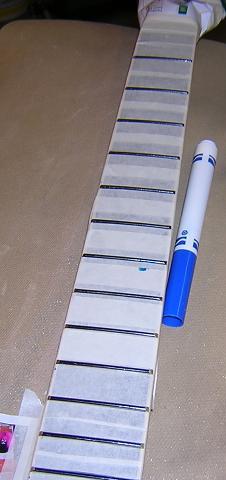 Marking the fret tops with blue marker.
