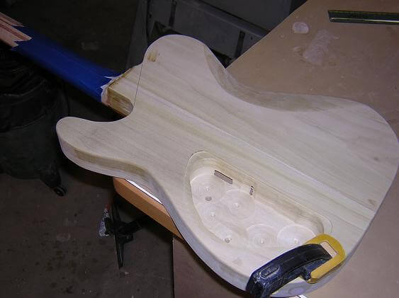 Clamping the guitar down, and taping the neck for protection.
