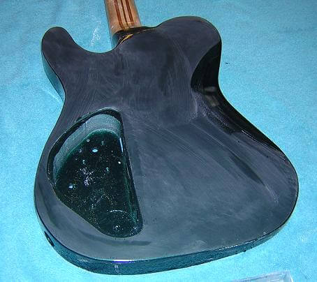 Continuing to sanding the guitar with 1000 grit sandpaper.