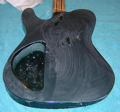 Final sanding the guitar with 2000 grit sandpaper.