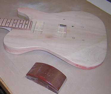 Sanding the guitar on a rubber sanding mat.