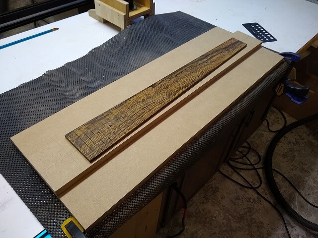 Affixing a fretboard to the jig.