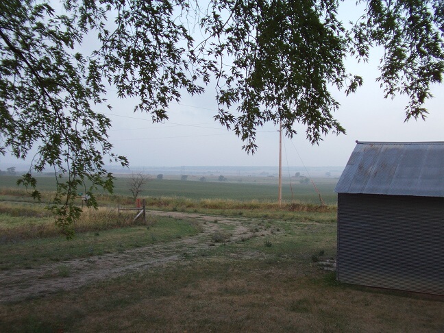 The farm looking past the garage to the south west, onto the neighbour's land.