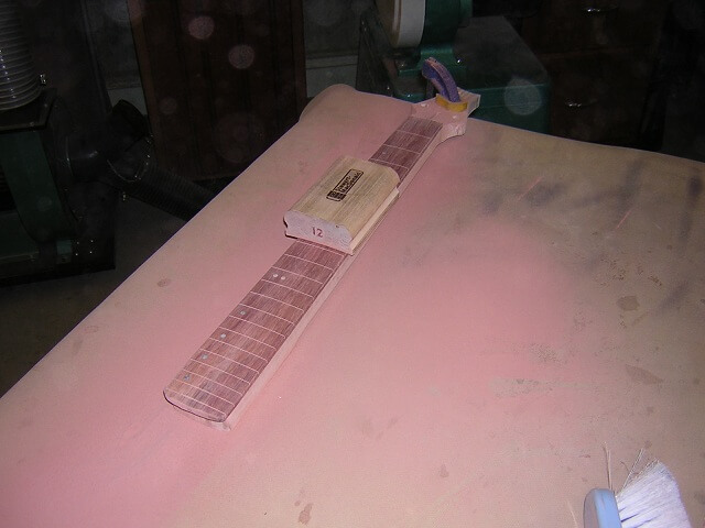 Sanding the radius in the fretboard.