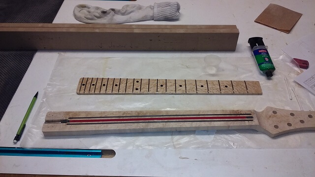 Preparing the glue the fretboard in place.