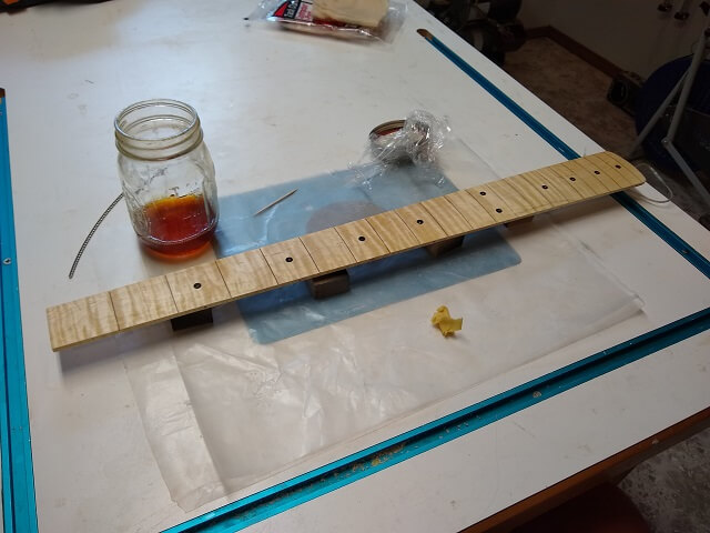 Applying shellac to the fretboard.