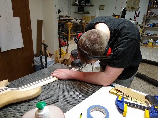 Sanding the back of the headstock smooth.