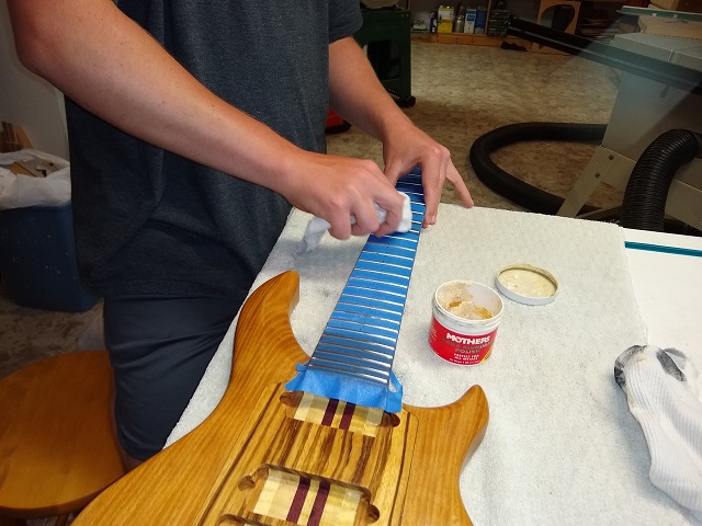 Polishing the frets.