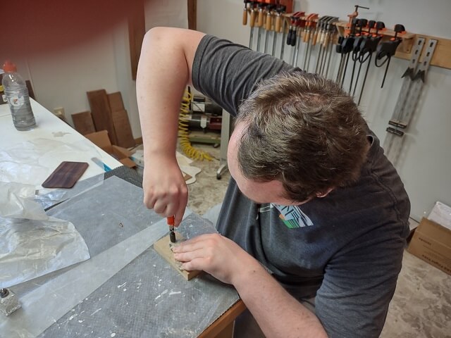 Countersinking the control cavity cover screw holes by hand.