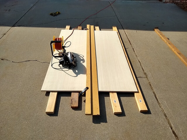 Using a sawboard to trim the cabinet side width.