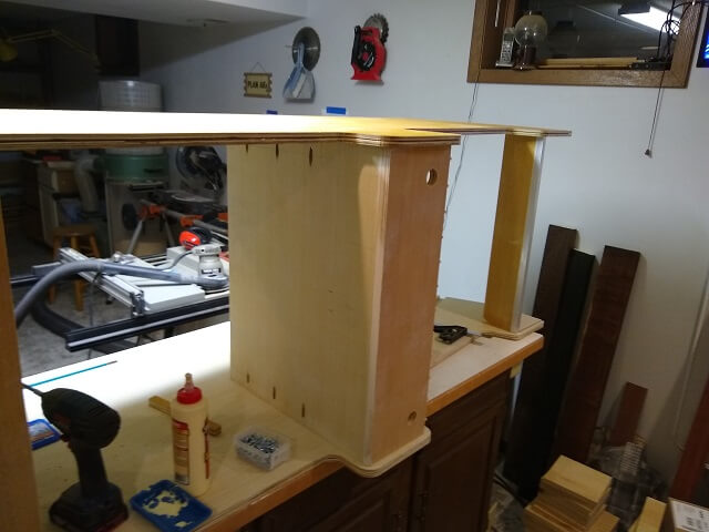 Attaching the other side of the cabinet to the control panel and marquee assemblies.