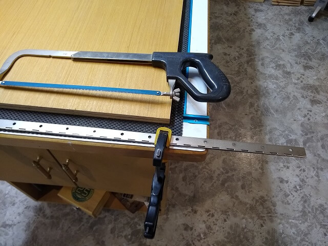 Trimming a piano hinge to length.