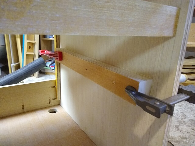Gluing the upper drawer spacers in place.