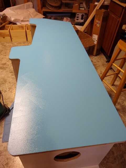 Painting the top coat of the side of the cabinet.